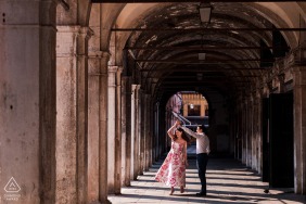 In Venice, Italy, a couple dances beneath the iconic arches, their elegant movements and the timeless architecture of the city combining for an unforgettable engagement portrait full of romance and charm.