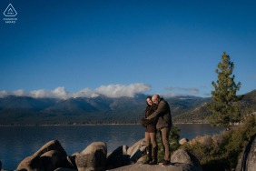 A couple celebrates their proposal in South Lake Tahoe, California, with the surrounding mountains and lake providing a stunning natural backdrop for their engagement portrait.