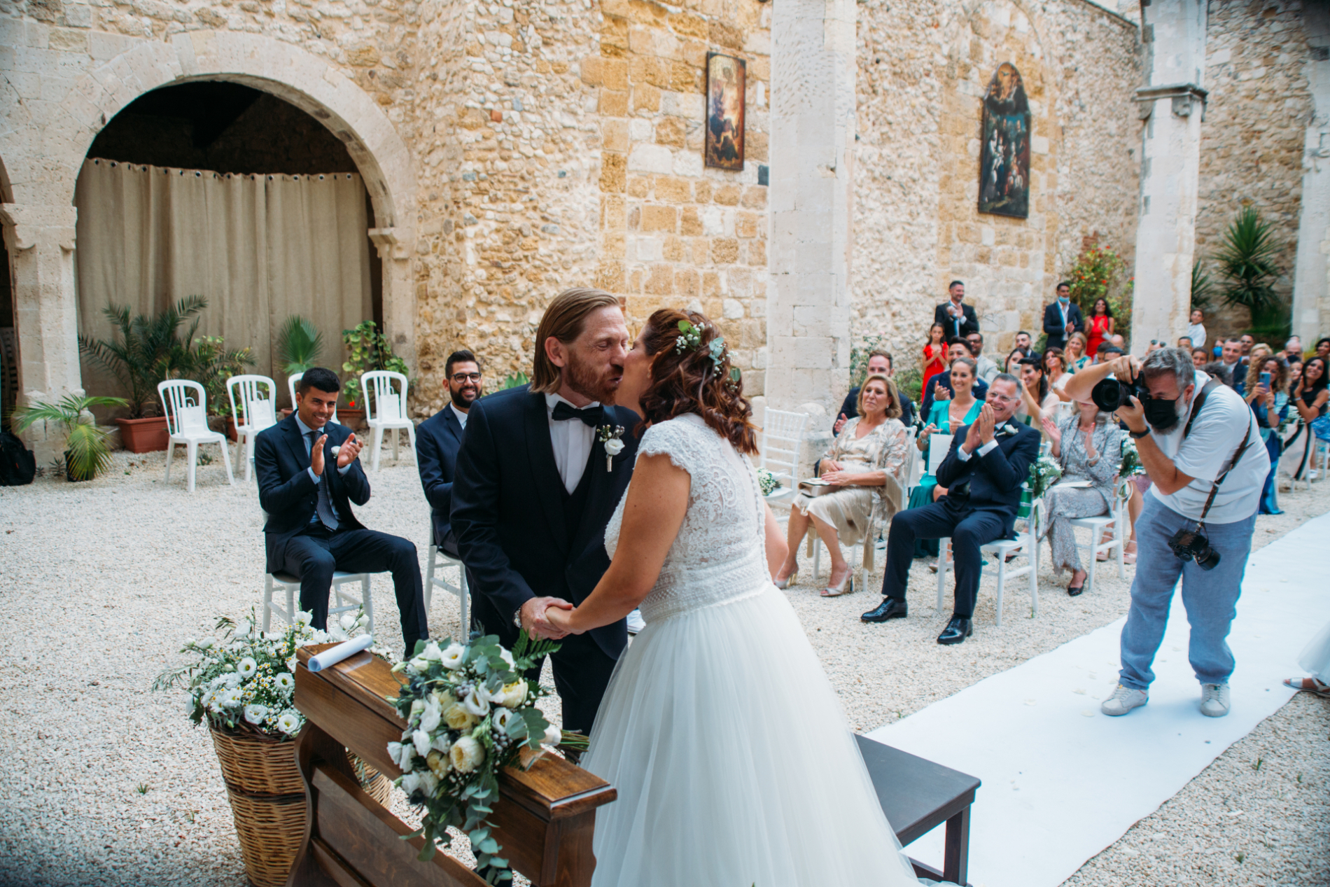 A Ragusa wedding photographer taking pictures of the kiss during the ceremony