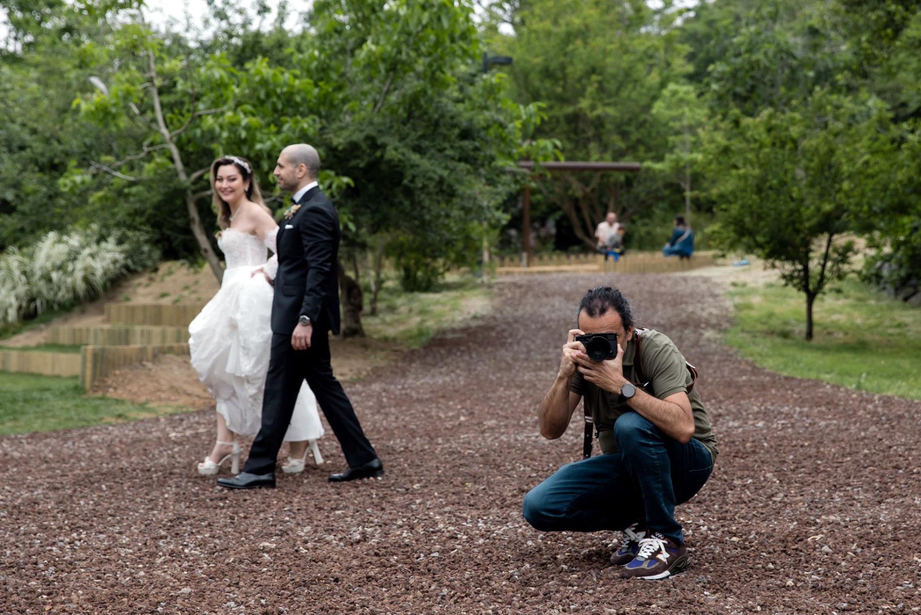  Istanbul Wedding Photographer Orçun Yalçın Taking Pictures in the Park as Couple Passes 