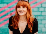 Jenna Kathleen, a wedding photographer in Greater Manchester, England, smiles in a lifestyle portrait.