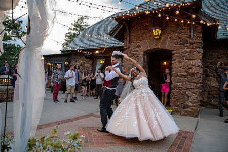 Wedding photo by Kevin Bergthold of the bride and groom dancing outdoors at the Boettcher Mansion venue.