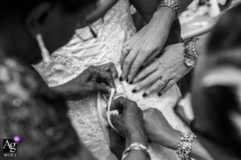 At the bridal prep in London, England, the bride's slim white dress was aided by devoted helpers