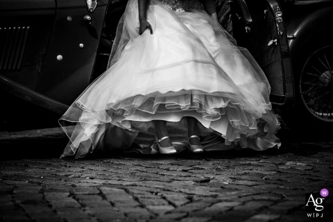 Netherlands wedding detail of the bride's dress while she gets into a car