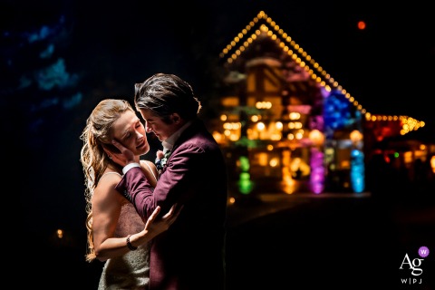 Romantic photo of bride and groom kissing under venue lights at Della Terra Mountain Chateau (Estes Park, CO) Romantic photo of bride and groom kissing under venue lights at Della Terra Mountain Chateau (Estes Park, CO)