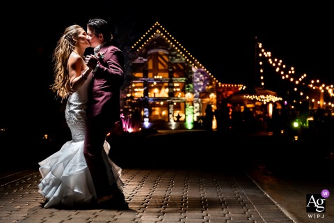 The newlyweds embraced on the dancefloor, the lights of their venue creating a romantic ambience for a creative nighttime portrait Della Terra Mountain Chateau, Estes Park, CO creative nighttime portrait of bride and groom with cool venue at night