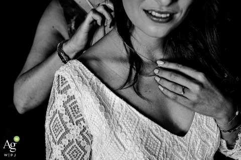 Artistic black and white Paris wedding photography showing details of the Brides best friend putting on the wedding collar 