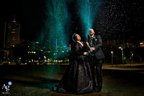 Colorado bride and groom spraying champagne at night at CU Denver campus