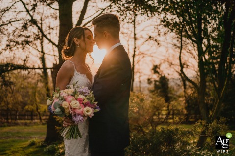 A romantic couple shares a passionate embrace as the warm hues of sunset bathe Bella Vista, England, in a breathtaking display of nature's beauty