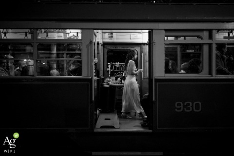 As the streetcar wedding nears its final stop, the bride walks past the open doorway of the train at the ceremony location, her movement marking the close of a memorable journey.