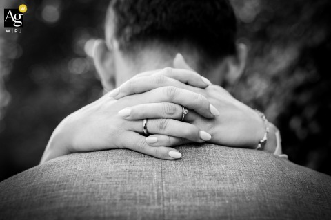 Bride hugs groom at Schloss Gimborn, showcasing engagement and wedding rings in the foreground.
