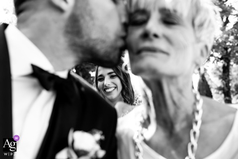Elegant Portrait: Bride Sees Groom Greet Mother Before Ceremony Bride watches groom greet his mother outside Santa Maria In Castelvecchio Church before their wedding ceremony.