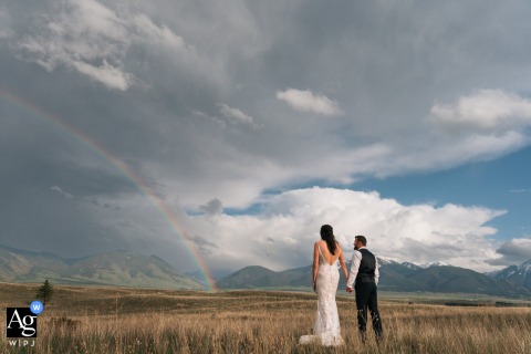 Wedding couple in Paradise Valley joyfully admire a rainbow together after a passing storm.