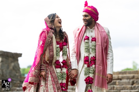Piedmont Park, Atlanta, GA: A couple in traditional red and white, holding hands and laughing with flower garlands.