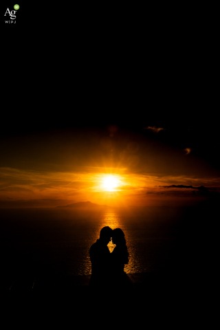 Sunset Over Villa Solaria Coastal Horizon In Massa Lubrense, Italy Highlights Evening Wedding Festivities The sun sets over the stunning coastal horizon at Villa Solaria in Massa Lubrense, Italy, providing a dramatic and warm backdrop for the couple's evening wedding festivities in Sorrento.