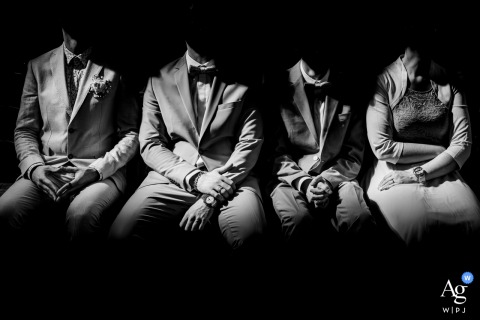 Black and white photo: four elegantly dressed people in church, shadowed faces, dramatic mysterious lighting.