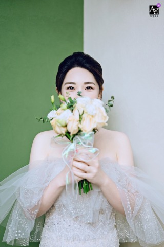 Bride in Nanping, Fujian, stands at home holding a bouquet of flowers.
