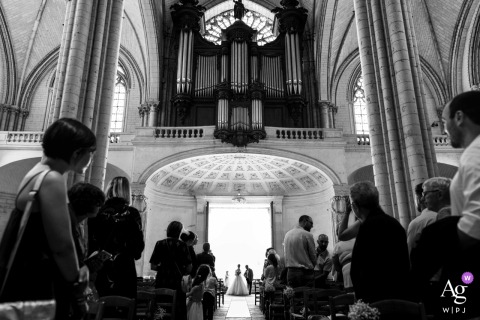 The bride makes her grand entrance into the majestic cathedral in Poitiers, Vienne, France.