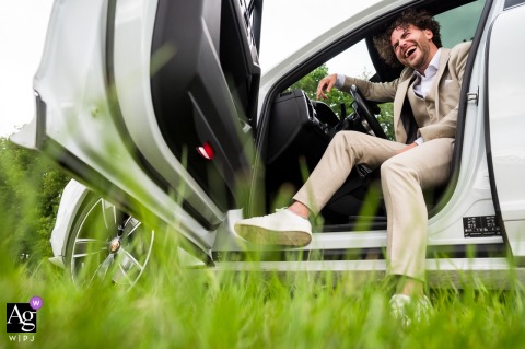 Bride’s son drives wedding car, laughing and having fun outside Bos & Co in Oosterhout, Netherlands.