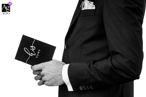 A black and white shot of the groom holding his vows book during the ceremony at Adligenswil, Lucerne.