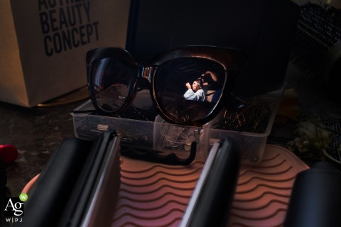 A creative reflection of the bride is seen in her sunglasses during her wedding preparations in Charente, France, offering a unique and modern perspective on the morning's events.