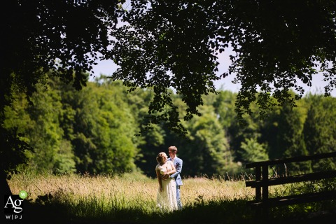 The newlyweds pose for a serene wedding portrait in a lush park in Amsterdam, Noord Holland, surrounded by vibrant greenery and the soft, natural light of the outdoors.