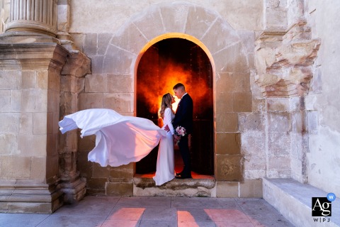Couple's portrait in an old-world stone archway in Cazorla, Jaén, Spain, beautifully backlit in red.