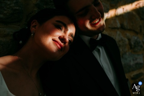 A ray of sunlight illuminates the bride and groom's faces at Domaine de la Trinité.