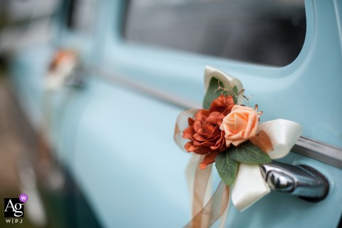 Wedding car floral decor on door, countryside near Frouzins, Haute-Garonne, colorful and elegant arrangement.