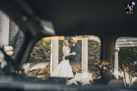 "Reflection in Love" captured through vintage car windows, framing a couple at Ca Borghese Ameglia.