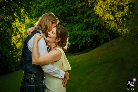 Bride and groom stand in wooded Sherbrooke Castle grounds, illuminated dramatically by off-camera flash.