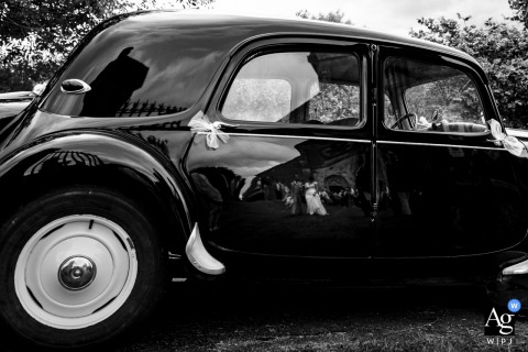 A poignant black and white shot: the couple's reflection in an old car as they leave the church in Bar le Duc.