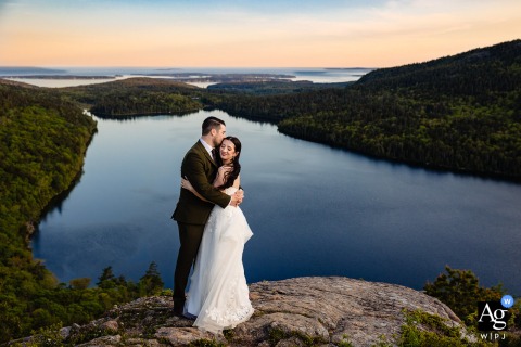 Elopement Portrait on Acadia National Park Mountaintop, Serene Low Sun Over Flat Water An elopement portrait on an Acadia National Park mountaintop, with a serene view of low sun over flat water.