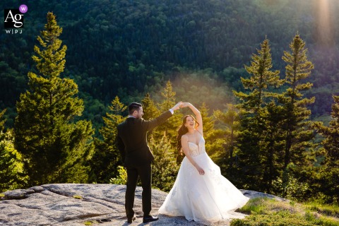 An elopement portrait of a couple joyfully twirling, spinning, and laughing in Acadia National Park, Maine.