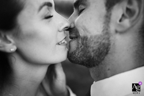 Tight black and white shot of the bride and groom's faces, eyes closed, sharing gentle smiles at Buccelletti Casali, Toscana, Italy.