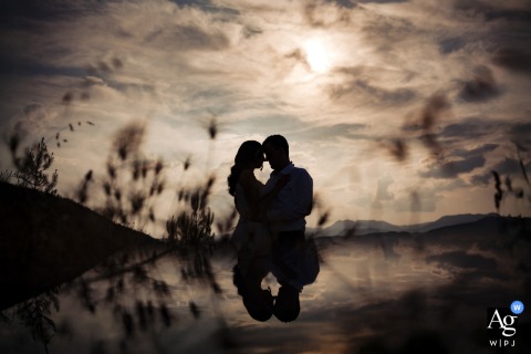 Silhouetted bride and groom's portrait in nature at Yanık Mektep İstanbul, with a warm-toned reflection.