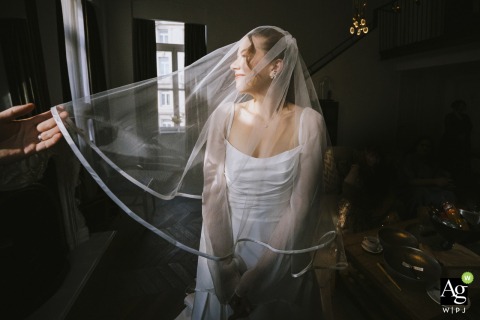 An artistic portrait at Soho House İstanbul features the bride under her veil, complemented by the gentle and symbolic placement of the groom's hand upon the delicate fabric.