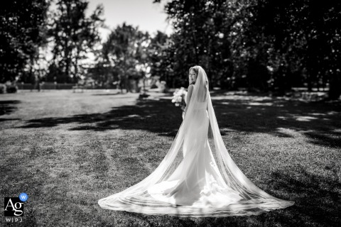 Black and white solo portrait of the bride on the grass by trees at Domaine du Rodier, Castelnau-Montratier, France.