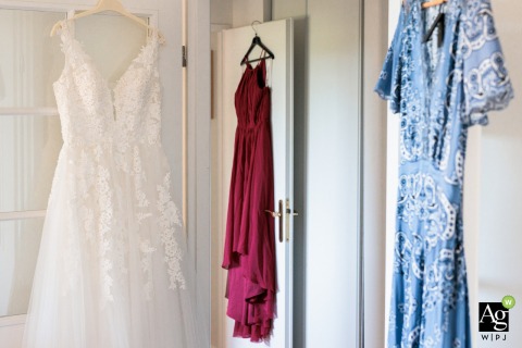 Elegant bridal and bridesmaid dresses hang in the bride's home in Versailles, Yvelines, waiting to be worn for the upcoming wedding festivities in this quiet interior scene.