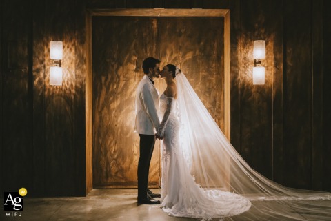A symmetrical, face-to-face wedding couple kiss captured at Soho House.