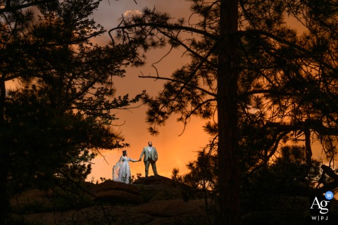 The bride and groom share a private, lit portrait session in the mountains with an orange sky, before their wedding in Fort Collins, Colorado.
