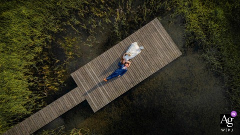 Halbinsel Au, Zürich, provides the setting for a unique drone portrait of the couple lying on their backs on a wooden boat dock, heads touching in a yin-yang composition.