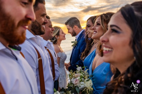 Destin, Florida is the setting for this artistic wedding day portrait where the happy bride and groom share a moment of intimate connection and warmth following their lively beach ceremony.