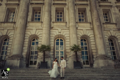 Standing before the grand facade of Moorpark Mansion in Rickmansworth, the couple poses for a classic portrait that utilizes the historic English estate as a majestic backdrop.