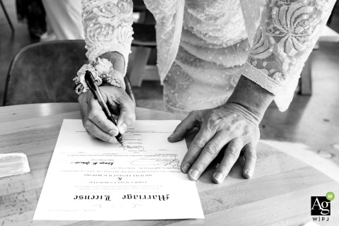 At Red’s Beer Garden in Atlanta, Georgia, an officiant signs the wedding license, capturing a vibrant and unique detail of this artistic and modern wedding celebration.
