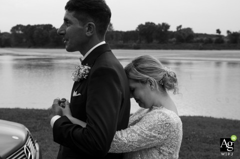 Following their portrait session at Lido Po in Guastalla, Italy, the bride shares an intense and heartfelt embrace with her groom amidst the serene landscape of Reggio Emilia.