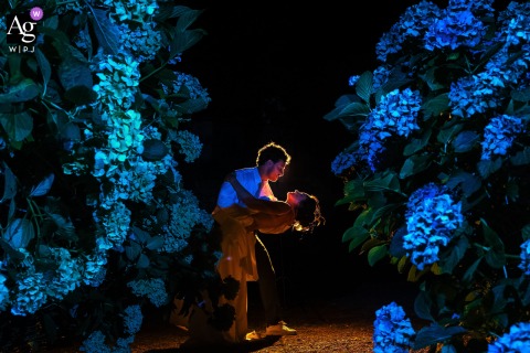 In Dordogne, Nouvelle-Aquitaine, France, a romantic dip is captured beneath the night sky at the bride's childhood home, framed by glowing blue hydrangeas.
