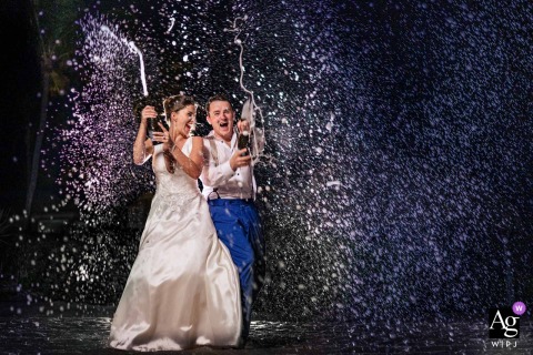 Key West, Florida hosts a dramatic, late-night wedding portrait of the couple embracing the wild energy of their reception with backlit spray and striking gelled lighting effects in a creatively composed scene.