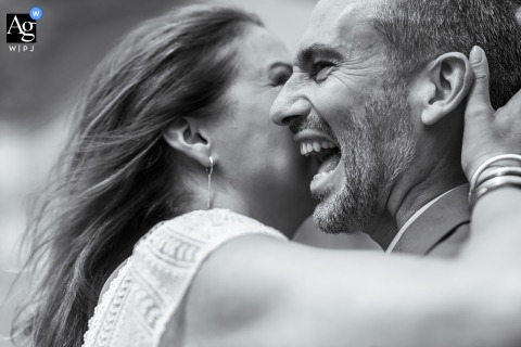 The bride whispers a secret into the groom's ear during their couple session in Lille, Nord, causing the groom to burst into a heartfelt and joyful fit of laughter.