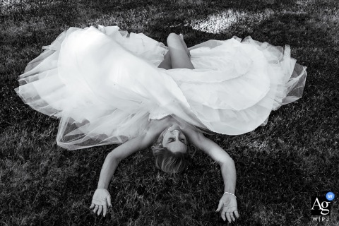Lille, France, provides the backdrop as the bride lies down on the grass to cool off from the intense heat, captured in a relaxed and candid portrait.